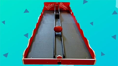 A Roller Ball Rental | Roller-Bowler-450x308, featuring a red and black design, sits on a blue surface with small blue triangular shapes in the background—making it an ideal choice for anyone looking to rent a fun roller bowler game in Wilmington, NC. Bounce house rentals Wilmington NC - Funtime Inflatables NC