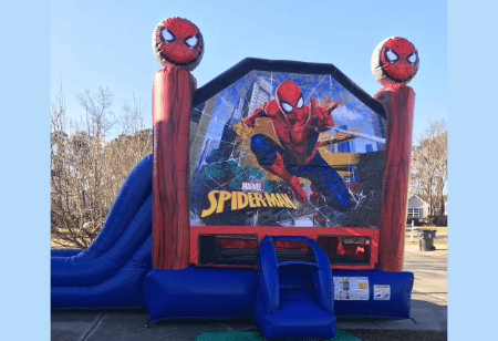 A funtime-inflatables-nc-rentals-spiderman-bounce-house-rental, complete with a slide and set up outdoors on a paved surface, is the perfect Spider-Man bounce house & slide combo rental Wilmington NC families will love for their next event. Bounce house rentals Wilmington NC - Funtime Inflatables NC